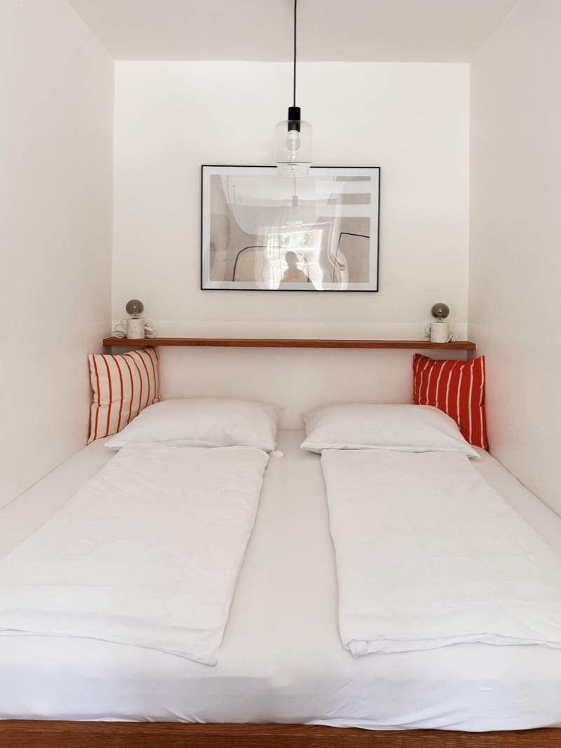 Schlafzimmer 2 in einer Nische mit Hängelampe und Kunst
